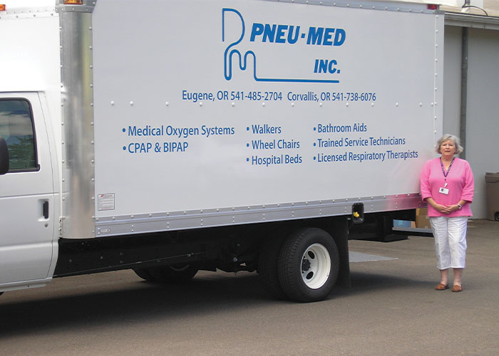 woman standing next to a Pneu Medical Delivery truck